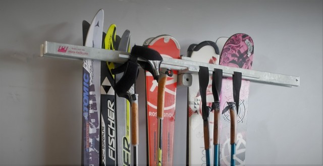 Stativ festet på vegg med ski og staver.